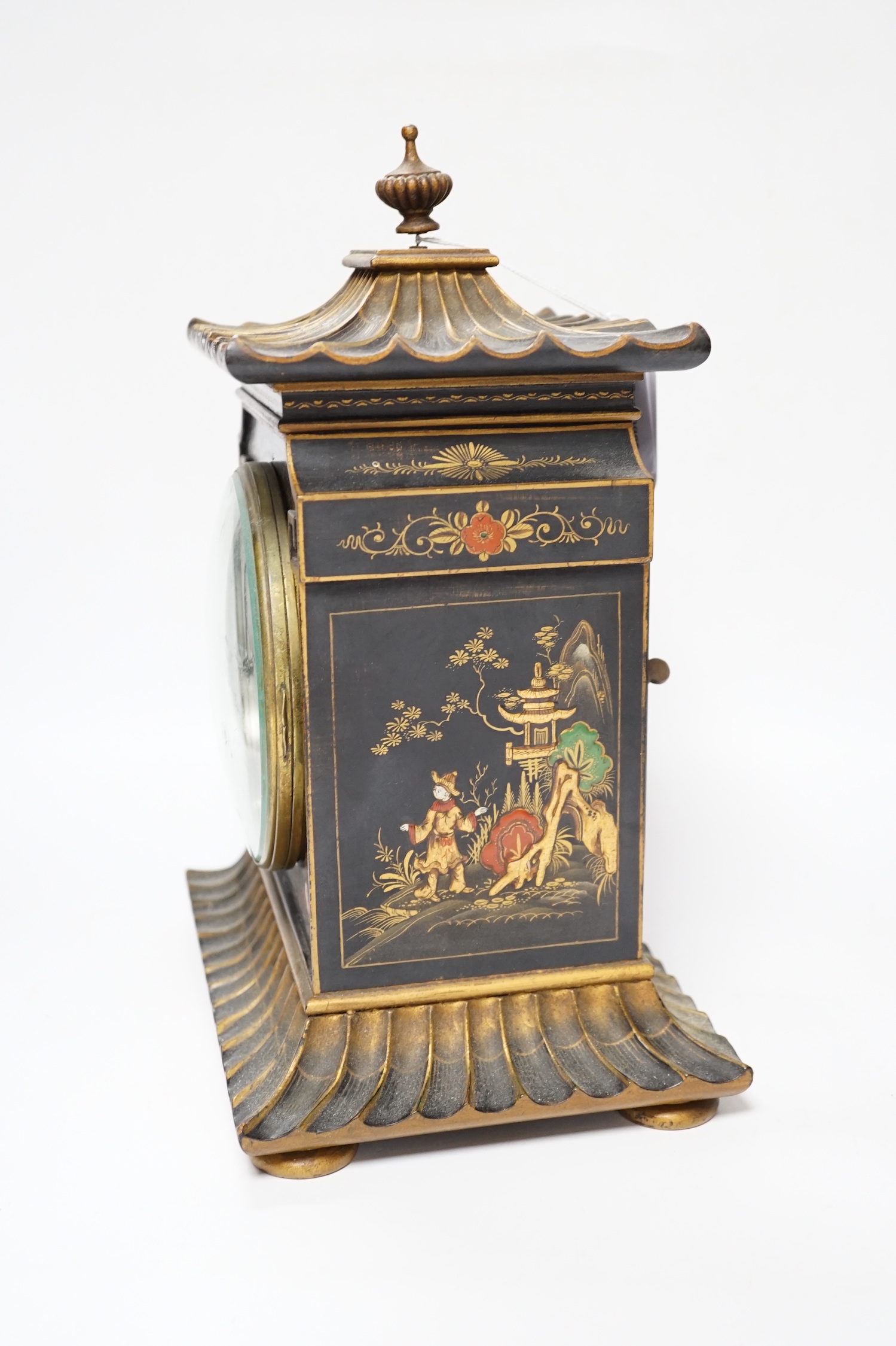 A George V chinoiserie lacquered mantel clock, decorated in relief with figures and pagodas, dial inscribed Birch & Gaydon, 31cm high